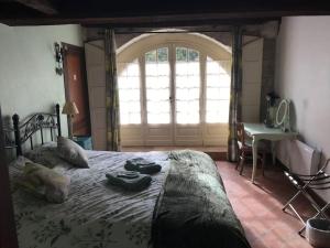 ein Schlafzimmer mit einem großen Bett und einem großen Fenster in der Unterkunft La Maison De La Tour Annex in La Sauvetat-du-Dropt