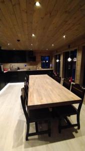 a large wooden table in a kitchen with chairs at Ny og moderne hytte i Stryn in Stryn