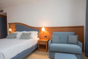 a hotel room with a bed and a chair at Hotel Centrale in Sabaudia