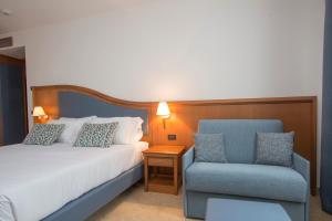 una camera d'albergo con letto e sedia di Hotel Centrale a Sabaudia