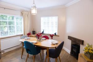 une salle à manger avec une table, des chaises et une cheminée dans l'établissement Romantic Cottage, à Plymouth