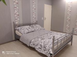 a bedroom with a bed with a gray and white bedspread at Park Villa Ferienwohnung mit Pool und 3 Schlafzimmer in Uelzen