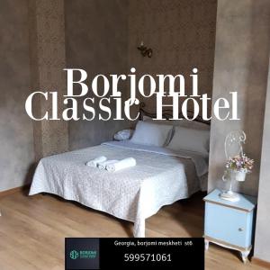 a sign for a hotel with a bed and a night stand at Borjomi Classic Hotel in Borjomi