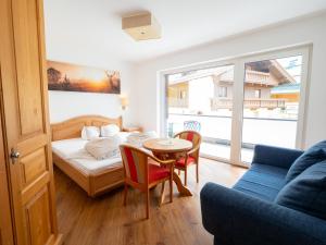 a living room with a bed and a table and chairs at Appartement Perauer in Mayrhofen