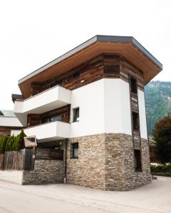 um grande edifício de tijolos com telhado de madeira em Appartement Perauer em Mayrhofen