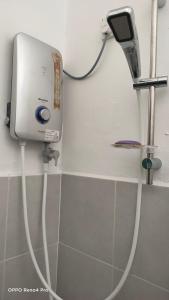 a hair dryer on the wall of a bathroom at Homestay Indera kayangan in Kangar