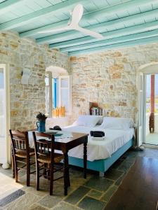 a bedroom with a bed and a table with chairs at Santa Maria Traditional Stone Studio in Santa Marina