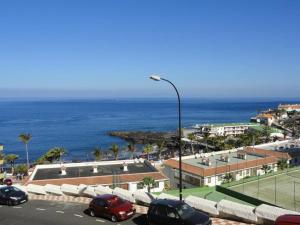 - un parking avec un court de tennis et l'océan dans l'établissement Ocean view apartment in front of Playa la Arena beach, à Puerto de Santiago