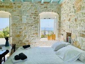 een slaapkamer met een groot wit bed in een stenen muur bij Santa Maria Traditional Stone Studio in Santa Marina
