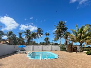 een zwembad in een tuin met palmbomen bij Pousada Recanto Vila Viçosa in Nova Viçosa