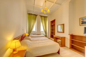 two beds in a bedroom with a window at Hotel Halaris in Ermoupoli