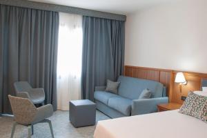 a hotel room with a bed and a couch at Hotel Centrale in Sabaudia