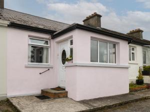 a white house with a white door and windows at 7 Aikenhead Terrace in Foxford