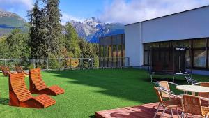 a patio with chairs and a table with a view of mountains at Hotel SOREA TRIGAN in Vysoke Tatry - Strbske Pleso
