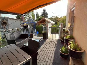 eine Terrasse mit einem Tisch, Stühlen und Topfpflanzen in der Unterkunft Ferienwohnung Bille in Pirna