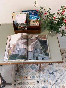 a table with an open book on a table with flowers at Au nom de la rose, beau 3 pièces en centre-ville in Provins +57 photos