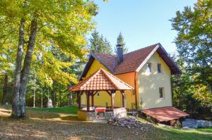 mały żółto-biały dom z altaną w obiekcie Vila Savinka w mieście Zlatibor