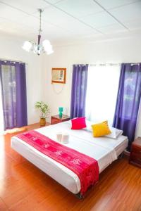 um quarto com uma cama grande e almofadas coloridas em Baki Divers and Beach Resort em Dauin