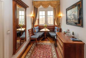 a home office with a mirror and a table and chairs at Schloss Hotel Wasserburg in Wasserburg am Bodensee