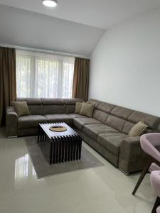 a living room with a couch and a table at Morpheus apartmani in Sremska Mitrovica