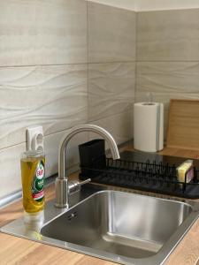 a bottle of beer sitting on a kitchen sink at Morpheus apartmani in Sremska Mitrovica