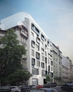 un grand bâtiment blanc avec des voitures garées dans un parking dans l'établissement VP Suites, à Budapest