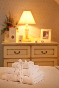 a pile of towels sitting on a bed with a lamp at Rókusfalvy Borhotel és Fogadó in Etyek +28 photos