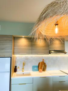 uma cozinha com um lavatório e um frigorífico em Sur la plage Valentin Beach Home - T3bis em Batz-sur-Mer