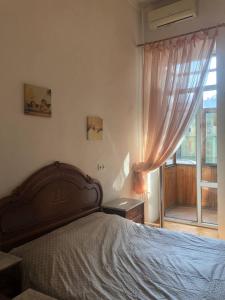 Un dormitorio con una cama grande y una ventana en Comfortable apartments near Gulliver, en Kiev