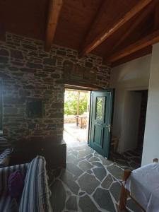 Cette chambre est dotée d'un mur en pierre et d'une porte verte. dans l'établissement Stone house Anatoli, à Mesokhória