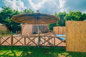 una mesa con una sombrilla en el césped en SAPANCA BAMBOOLOW RESORT, en Sakarya