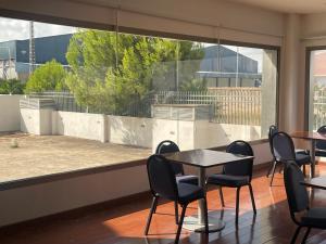 Cette chambre dispose d'une grande fenêtre et d'une table avec des chaises. dans l'établissement Cityexpress Hotel San Fernando - Carcaixent, 