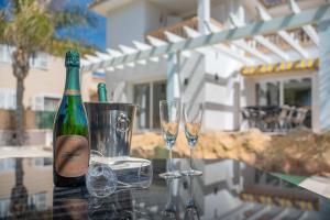 eine Flasche Champagner und zwei Gläser auf dem Tisch in der Unterkunft Villa Sol Felostal in Palma de Mallorca