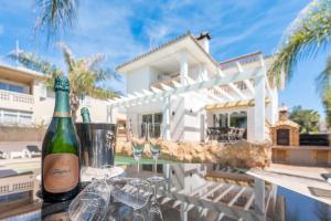 a bottle of wine sitting on a table with two glasses at Villa Sol Felostal in Palma de Mallorca