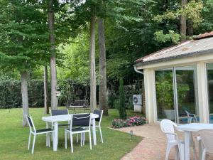 um grupo de mesas e cadeiras num jardim em Rose Garden Studio em Giverny