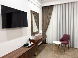 a hotel room with a television and a desk and a chair at Reikartz Sote Tashkent in Tashkent
