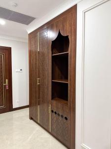 a wooden cabinet with a glass door in a room at Reikartz Sote Tashkent in Tashkent