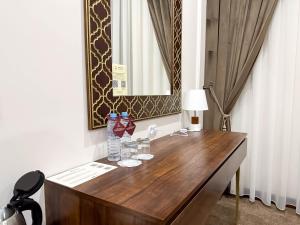 a bathroom with a wooden desk with a sink and a mirror at Reikartz Sote Tashkent in Tashkent