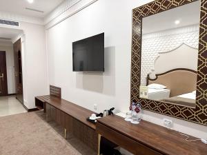 a hotel room with a mirror and a bed at Reikartz Sote Tashkent in Tashkent