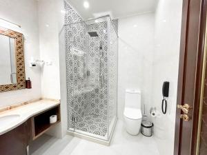 a bathroom with a shower and a toilet and a sink at Reikartz Sote Tashkent in Tashkent