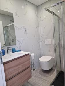 a bathroom with a toilet and a sink and a shower at Ocean Paradise do Til in Funchal