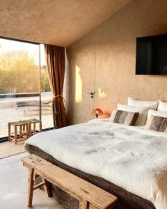 a bedroom with a large bed and a large window at Hoeve La Cascina in Deinze