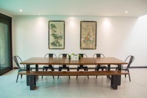 une table à manger avec des chaises et des peintures murales dans l'établissement Tropical Poolhouse QC, à Manille