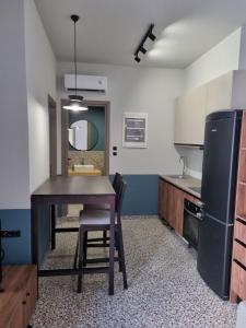 a kitchen with a table and a sink and a refrigerator at MOD 15 City Centre in Agios Nikolaos