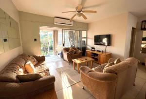 a living room with two couches and a tv at The Bridge No 37 in St Lucia