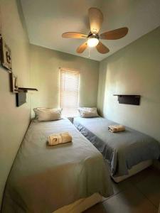 um quarto com 2 camas e uma ventoinha de tecto em The Bridge No 37 em St. Lucia