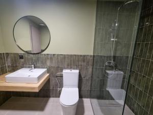 een badkamer met een toilet, een wastafel en een spiegel bij MOD 15 City Centre in Agios Nikolaos