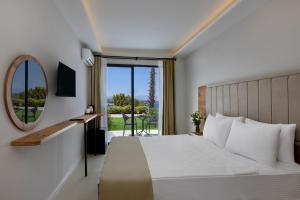 una camera d'albergo con letto e specchio di Sun Pearl Resort Çeşme a Smirne