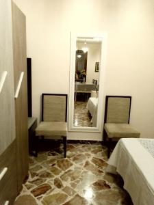 een kamer met 2 stoelen en een spiegel bij Da Giusy le petit bijou in Castelbuono