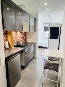 a kitchen with stainless steel appliances and a table at Apartament Bronowice 2 in Kraków